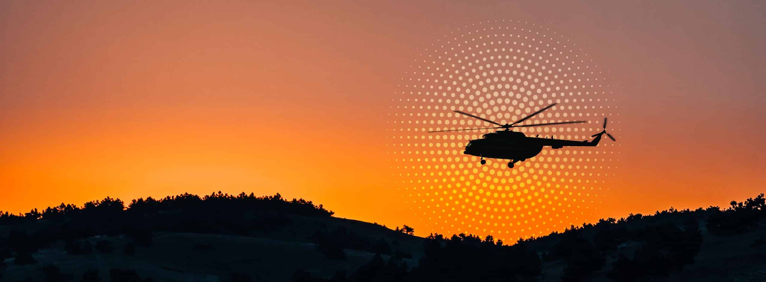 helicopter flying over a hill
